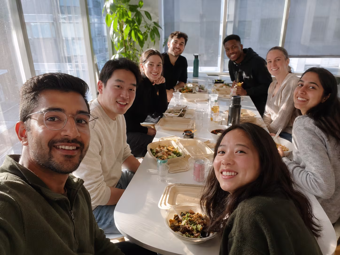 The Chatref team sharing lunch together around a table in a bright, window-lit office